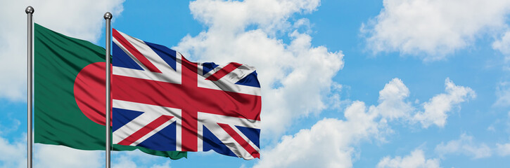 Bangladesh and United Kingdom flag waving in the wind against white cloudy blue sky together. Diplomacy concept, international relations.