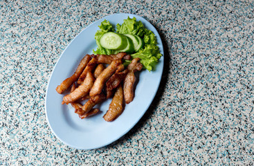 Sliced pork roasted thai style with green leaves salad on rustic plate with cutlery.charcoalboiled pork neck Grill pork Thai style food