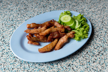 Sliced pork roasted thai style with green leaves salad on rustic plate with cutlery.charcoalboiled pork neck Grill pork Thai style food