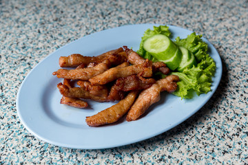 Sliced pork roasted thai style with green leaves salad on rustic plate with cutlery.charcoalboiled pork neck Grill pork Thai style food