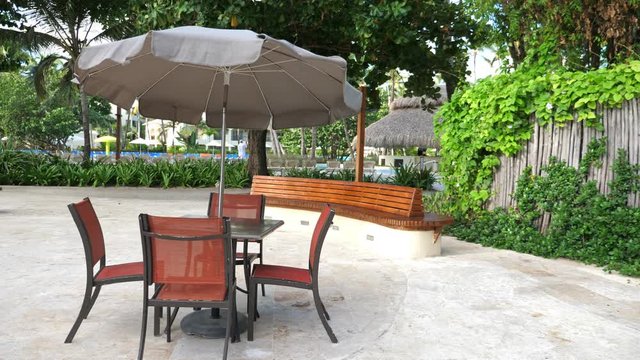 Outdoor cafe with sunumbrella, table and chairs on tropical island. Nobody