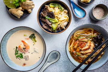 Set of Serving Asian Soups on gray background top view. Tom Yum Soup, Eel Fish Soup and Ramen noodle Soup