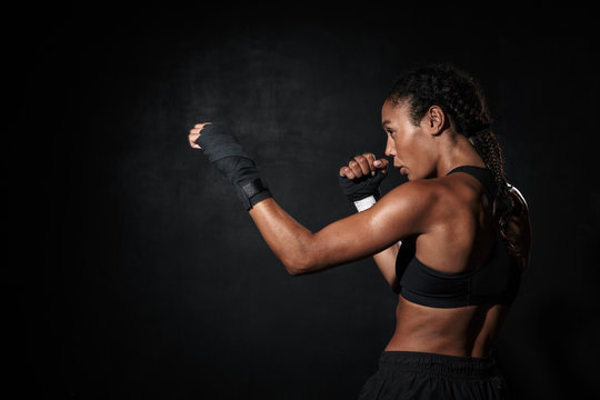 Image of healthy african american woman boxing in hand wraps