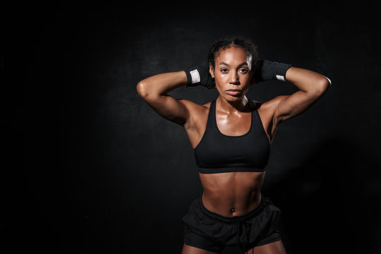 Image of strong african american woman standing in boxing hand wraps