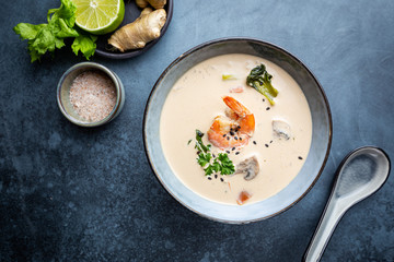 Tom Yum Kung soup, a Thai traditional spicy prawn soup in a bowl on gray background, top view
