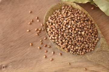 Wooden spoon of roasted buckwheat. gluten free ancient grain for healthy diet, selective focus