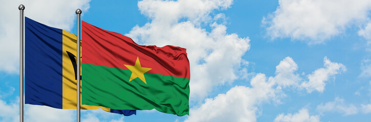 Fototapeta na wymiar Barbados and Burkina Faso flag waving in the wind against white cloudy blue sky together. Diplomacy concept, international relations.