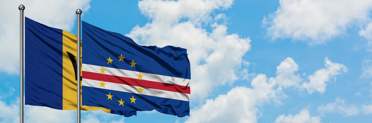 Barbados and Cape Verde flag waving in the wind against white cloudy blue sky together. Diplomacy concept, international relations.