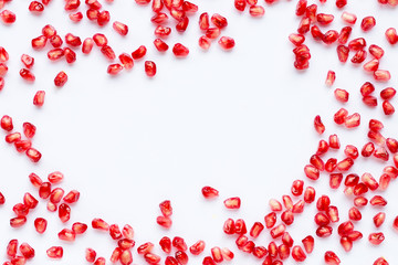 Frame made of pomegranate seeds isolated on white background.