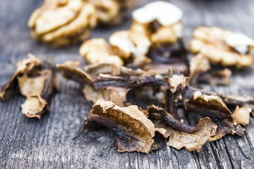 Walnut kernels and partitions near whole walnuts on a wooden table. The medicine for tinctures and decoctions.