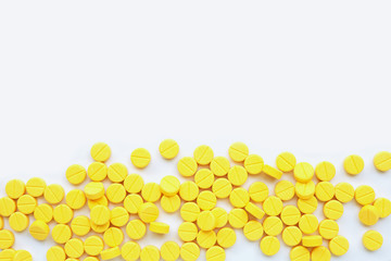 Yellow tablets of Paracetamol on white background.