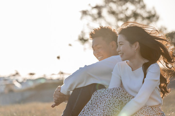 陽の当たる広場で遠くを見つめるカップル