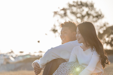 陽の当たる広場で遠くを見つめるカップル