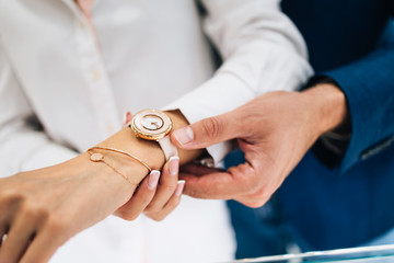 Beautiful couple enjoying in shopping at modern jewelry store. Close up shot of human hand holding...