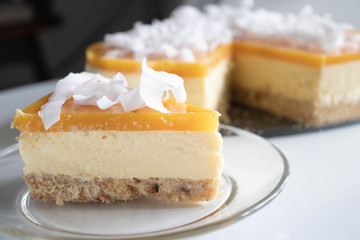 A piece of Mango Cheesecake with coconut chips.