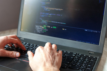 Programmer coding on laptop. Coder hands typing program code