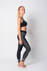 Fototapeta premium Full body shot profile view of young blonde woman ready for gym