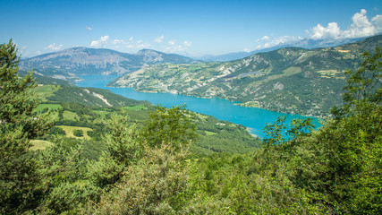 Majestic mountain lake Serre-Ponçon (Lac de Serre-Ponçon) is a lake in southeast France  it is one of the largest artificial lakes in western Europe. HD wallpaper, 4k green background © Jan