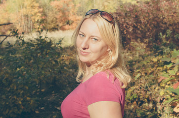 Portrait of a mature blnd woman relaxing in the autumn colored forest