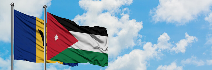 Barbados and Jordan flag waving in the wind against white cloudy blue sky together. Diplomacy concept, international relations.