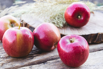 Pile of red fresh apples on a wooden table. Vitamins and a healthy diet. Vegetarian concept.