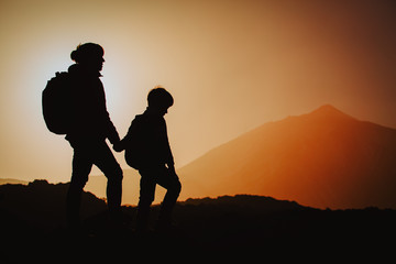 mother and son travel in mountains at sunset, family hiking