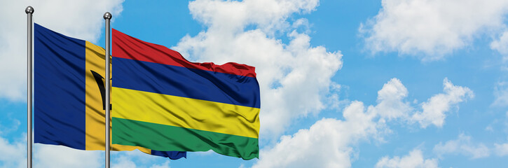 Fototapeta na wymiar Barbados and Mauritius flag waving in the wind against white cloudy blue sky together. Diplomacy concept, international relations.