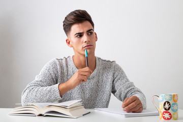 Thoughtful teenager studying on a desk