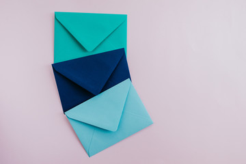 Colored paper envelopes on a light background. New mail, write message. Send and receive letter. Postal delivery service. Blank envelope, empty space. People communication, paperwork. Envelope closeup