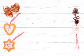 Weihnachtsbäckerei mit einer Schleife, Tannenzapfen und Herz auf einem Weißen Holz Hintergrund