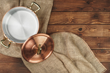 Copper pot on the dark wooden table, top view