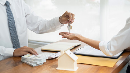 Real estate agent and customer signing contract to buy house, insurance or loan real estate.