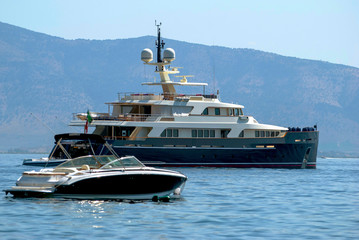 Black luxury yacht anchored near the shore
