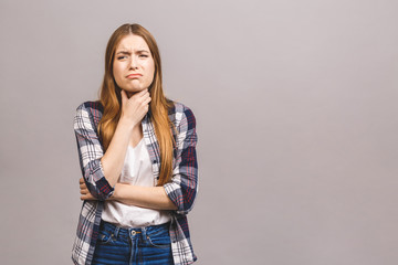 Closeup portrait of cute sick young blonde woman in casual having sore throat, holding hand on her neck/Throat pain, painful swallowing concept/ Inflammation of the upper respiratory tract.