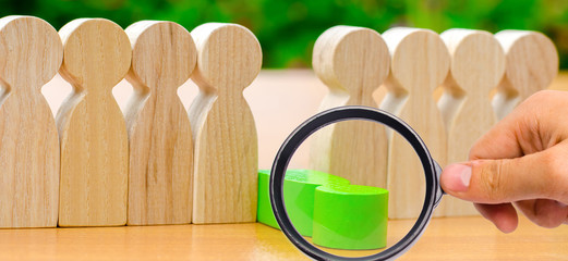 The green figure of a man falls out of the line of people. Concept of employee dismissal and team...