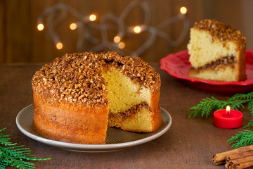 Almond cinnamon cake with christmas lights on wooden table. Close up