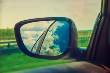 Fototapeta premium Landscape in the sideview mirror of a car