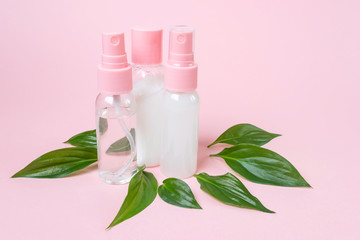 Transparent bottles with organic cosmetics on a pastel pink background. Concept of eco friendly...