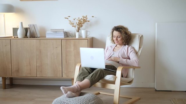 Pregnant Woman Working On Laptop Computer At Home. Pregnancy And Maternity Leave.