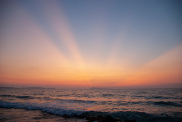 The rays of the setting sun cut through the sky