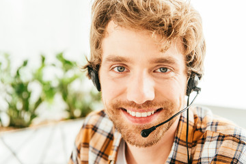 cheerful and bearded broker looking at camera in office