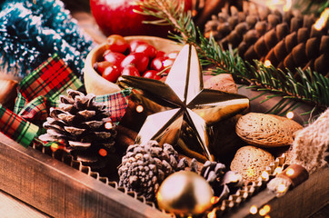 Variety of Christmas and New year decorations  in wood tray over rustic background.  Flat lay, space.