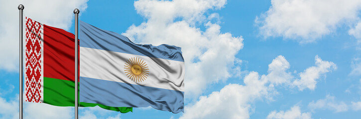 Belarus and Argentina flag waving in the wind against white cloudy blue sky together. Diplomacy concept, international relations.