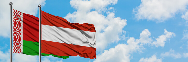 Fototapeta na wymiar Belarus and Austria flag waving in the wind against white cloudy blue sky together. Diplomacy concept, international relations.