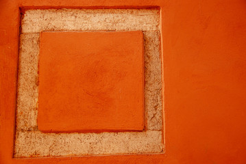 The orange square is carved into a stone wall. Place for text. Copy space
