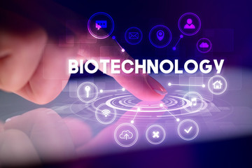 Finger touching tablet with web technology icons and BIOTECHNOLOGY inscription, web technology concept
