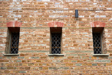Old brick wall with three windows. Wall and windows