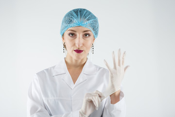 Female doctor puts on medical rubber gloves
