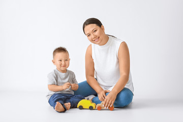 Fototapeta premium Portrait of Asian mother with cute baby boy on white background