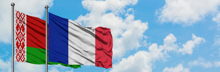 Belarus and France flag waving in the wind against white cloudy blue sky together. Diplomacy concept, international relations.